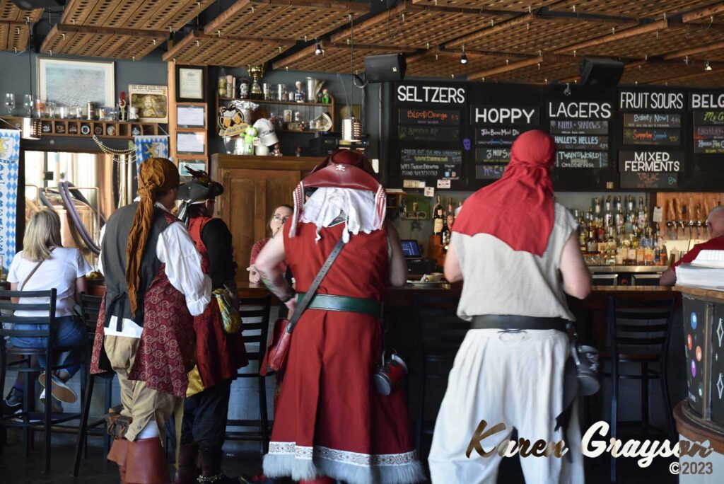 A group of pirates stand at the bar at Twain's Billliards & Brewpub. PiratePalooza 19. Photo by Karen Grayson, copyright 2023