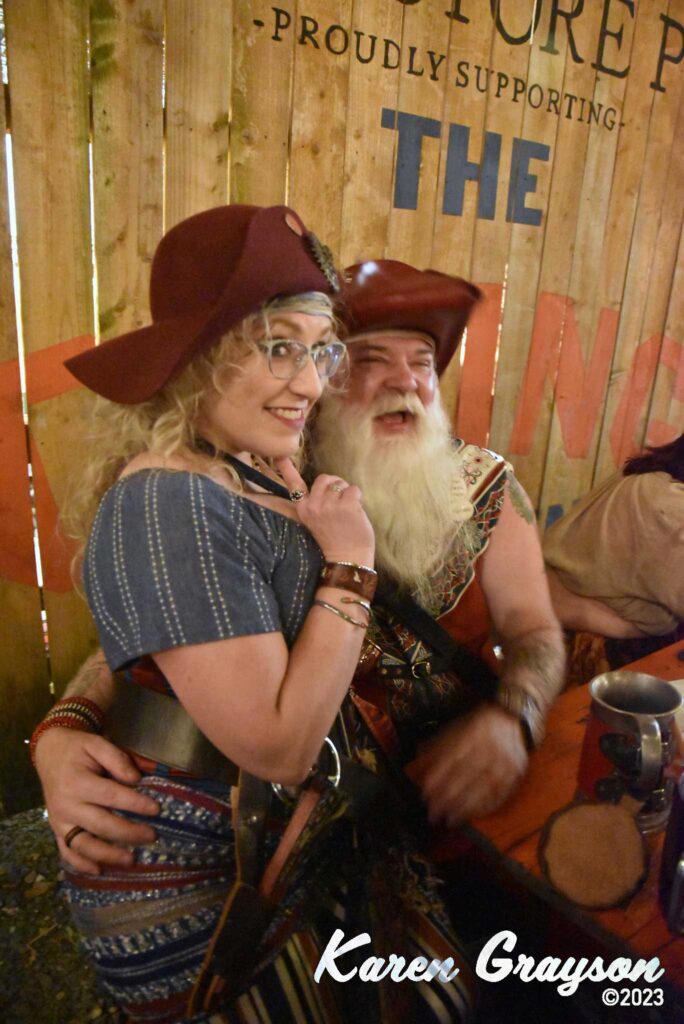 A naughty pirate wench asking Pirate Santa for something in her stockings in the Brick Store Pub garden. PiratePalooza 19. Photo by Karen Grayson, copyright 2023